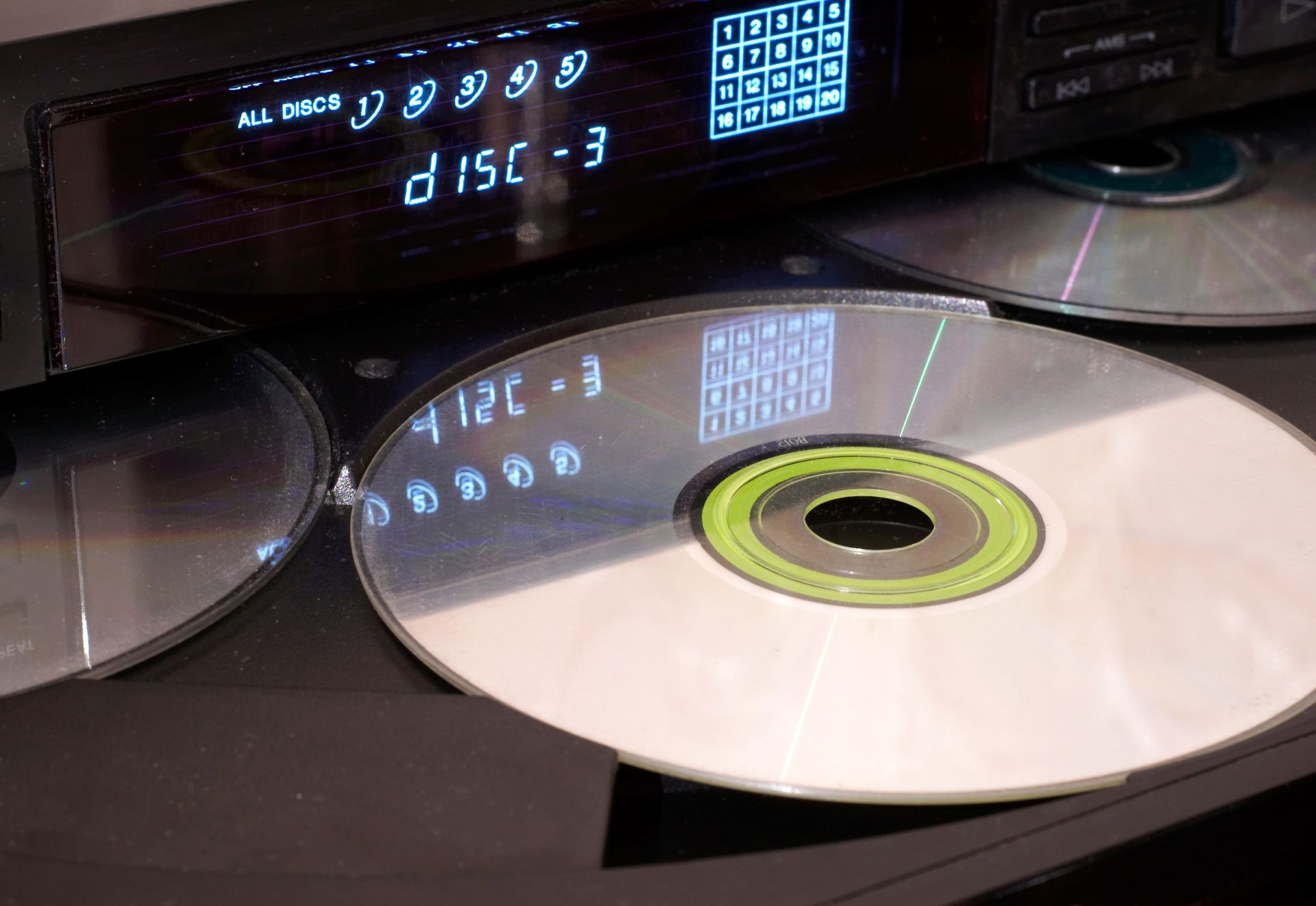 CD-Player mit eingelegter CD, Anzeige zeigt 'disc - 3' und eine Auswahl von fünf Discs