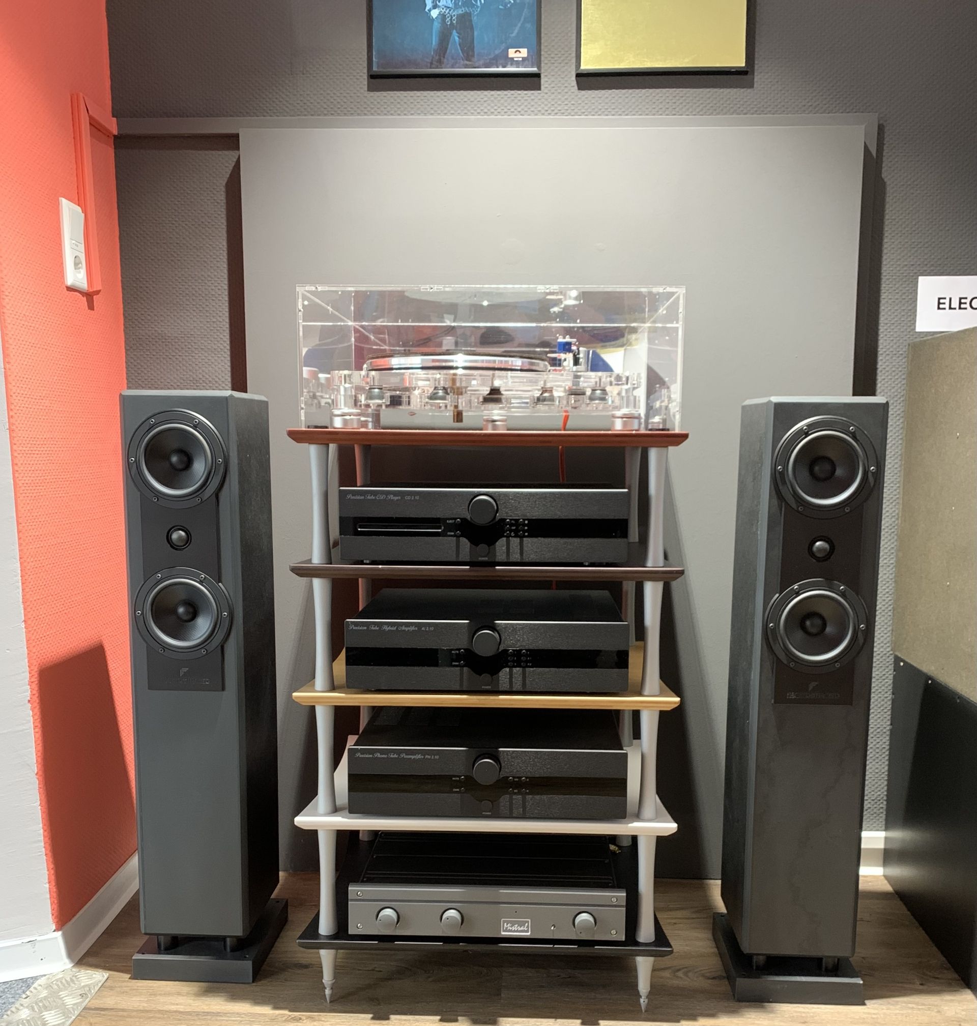 HiFi-Anlage mit zwei schwarzen Standlautsprechern und einem Regal mit Plattenspieler und Verstärkern