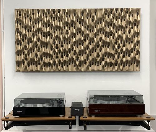 Zwei Thorens Plattenspieler auf Holzregalen unter einem großen, strukturierten Wandrelief mit ovalen Vertiefungen